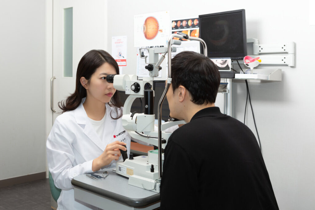 스마트라식 수술 후 업무상으로 도수안경이 꼭 필요한 환자로 인해 검사 및 진료를 통하여 착용여부를 확인하고 있는 누네안과병원 시력교정 전문의 신경윤 원장님